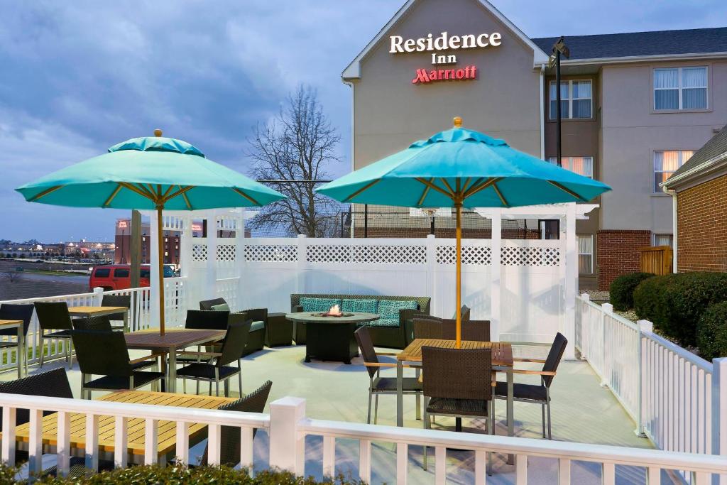 un patio con mesas, sillas y sombrillas en Residence Inn by Marriott Dallas Lewisville, en Lewisville