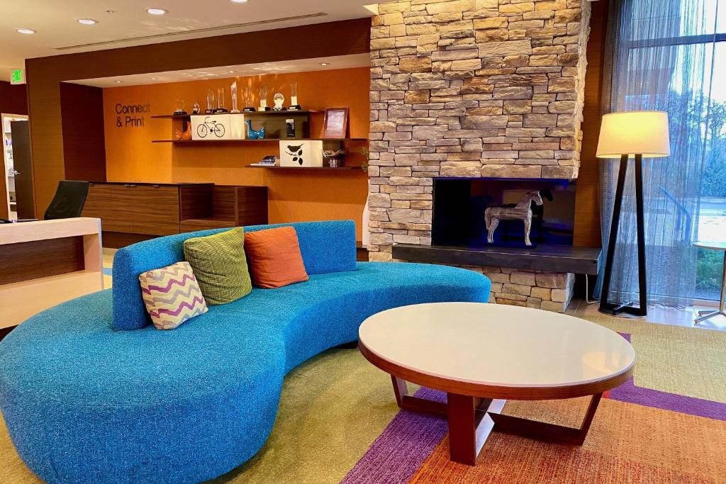 a blue couch in a living room with a fireplace at Fairfield by Marriott The Dalles in The Dalles