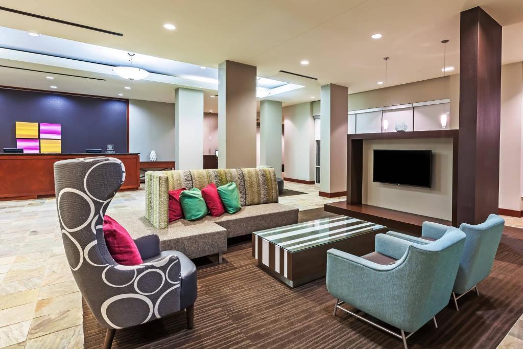 a lobby with a couch and chairs and a tv at Residence Inn Houston West Energy Corridor in Houston