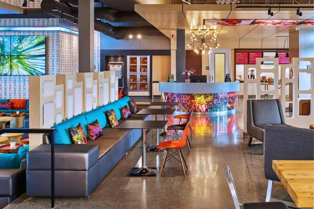 a restaurant with tables and chairs and a bar at Aloft Chesapeake in Chesapeake