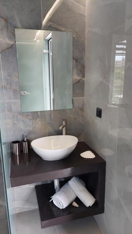 a bathroom with a sink and a mirror at Luana Monte Apartments in Amoudara Herakliou