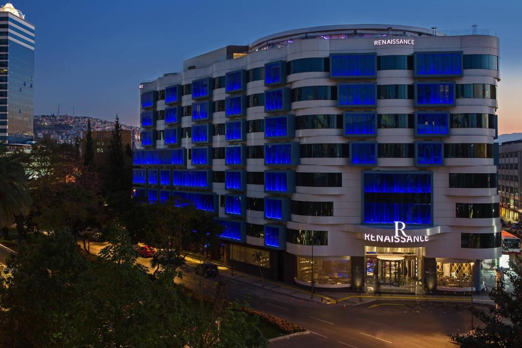 hotel z niebieskimi światłami na boku budynku w obiekcie Renaissance Izmir Hotel w mieście Izmir