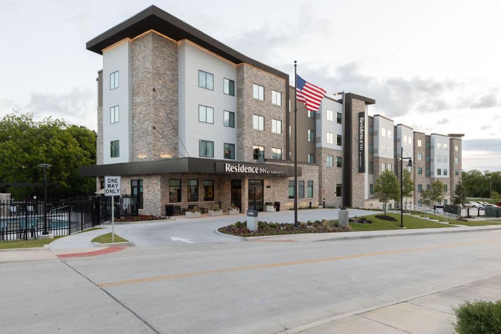 ein Hotel mit amerikanischer Flagge davor in der Unterkunft Residence Inn by Marriott Fort Worth Southwest in Fort Worth
