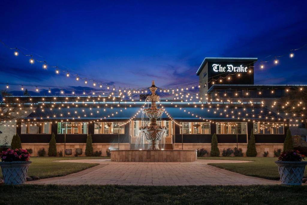 un edificio con luci e una fontana di fronte ad esso di The Drake Oak Brook, Autograph Collection a Oak Brook