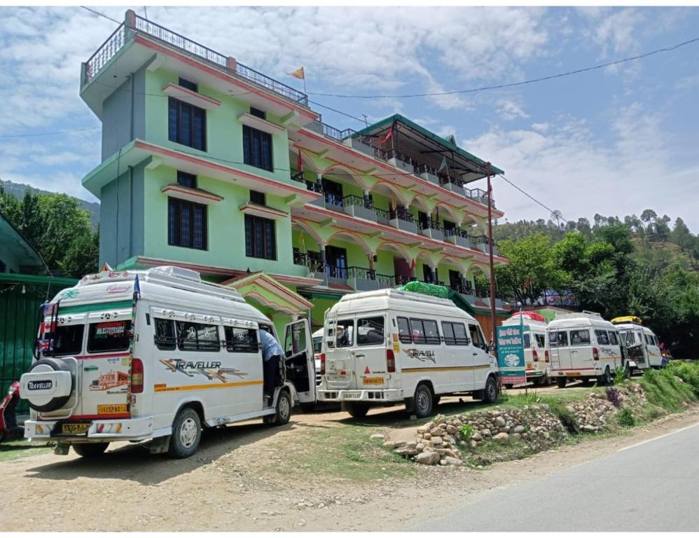 a group of vehicles parked in front of a building at Hotel Gaurishankar Palace, Barkot in Barkot