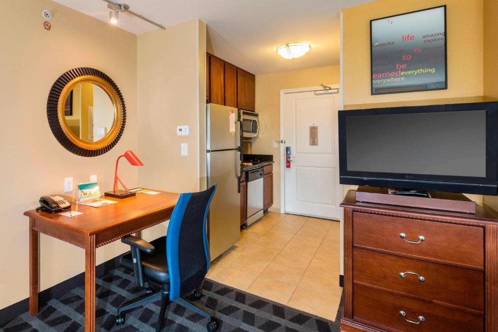 TownePlace Suites Houston North/Shenandoah في ذا وودلاندس: غرفة معيشة مع مكتب وتلفزيون ومكتب sidx sidx sidx