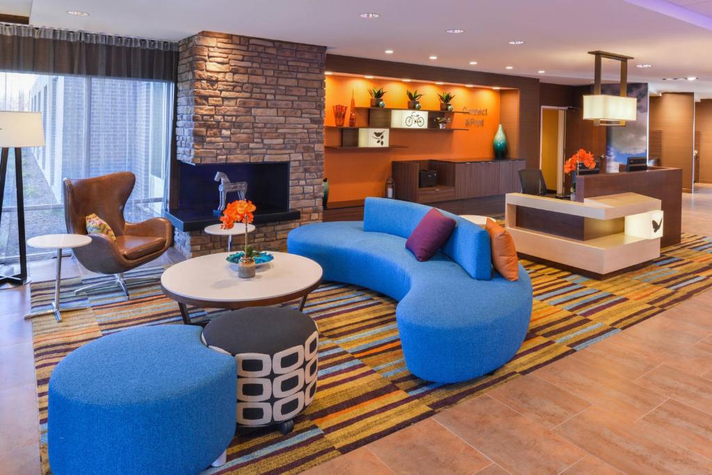 um átrio com um sofá azul, uma mesa e cadeiras em Fairfield Inn & Suites by Marriott Coralville em Coralville