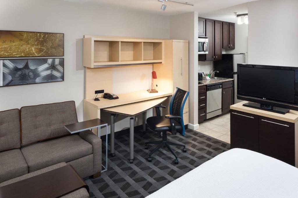 a living room with a desk and a couch and a television at TownePlace Suites Columbia Southeast / Fort Jackson in Columbia