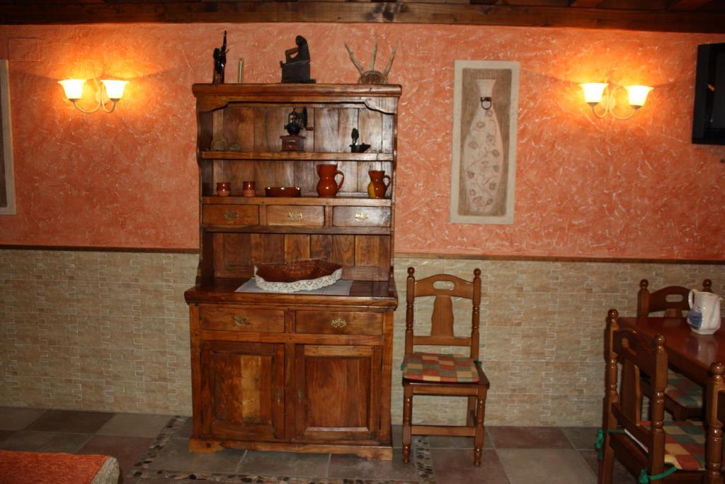 a room with a wooden cabinet and a chair at La Cabaña in Mozoncillo de Juarros