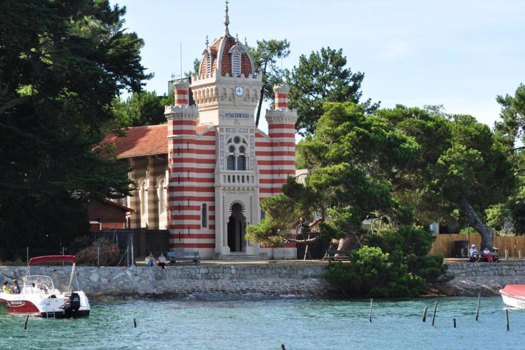 budynek z wieżą zegarową obok wody w obiekcie L'annexe, Village de l'Herbe w mieście Lège-Cap-Ferret