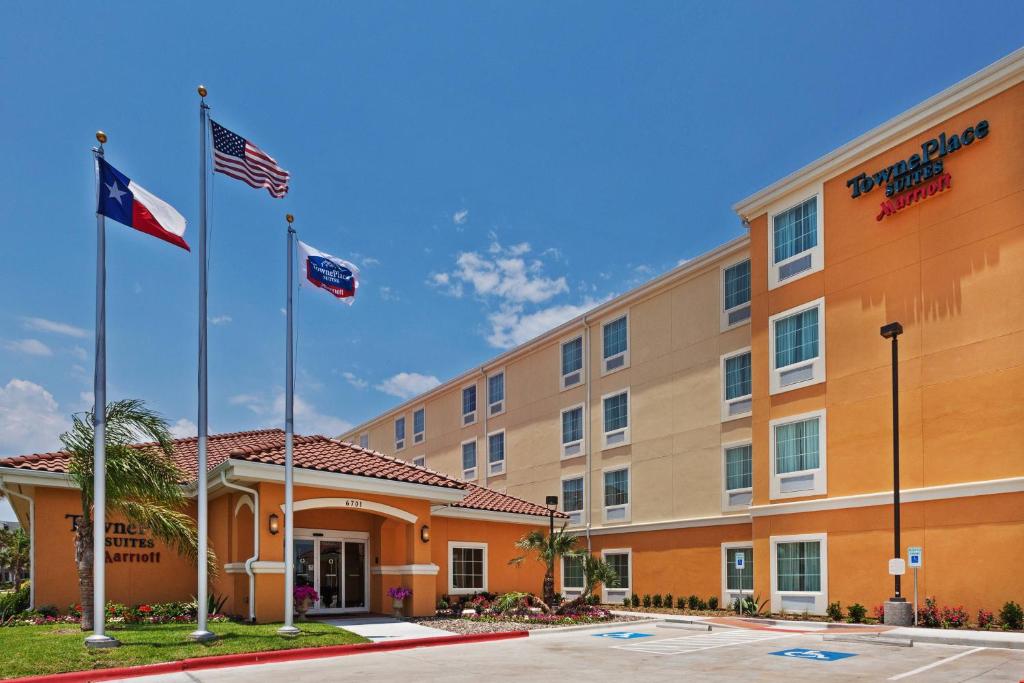 an exterior view of a hotel with two flags at TownePlace Suites by Marriott Corpus Christi in Corpus Christi