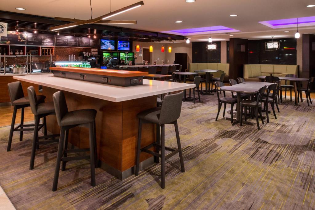 a bar with tables and chairs in a restaurant at Courtyard by Marriott Victorville Hesperia in Hesperia
