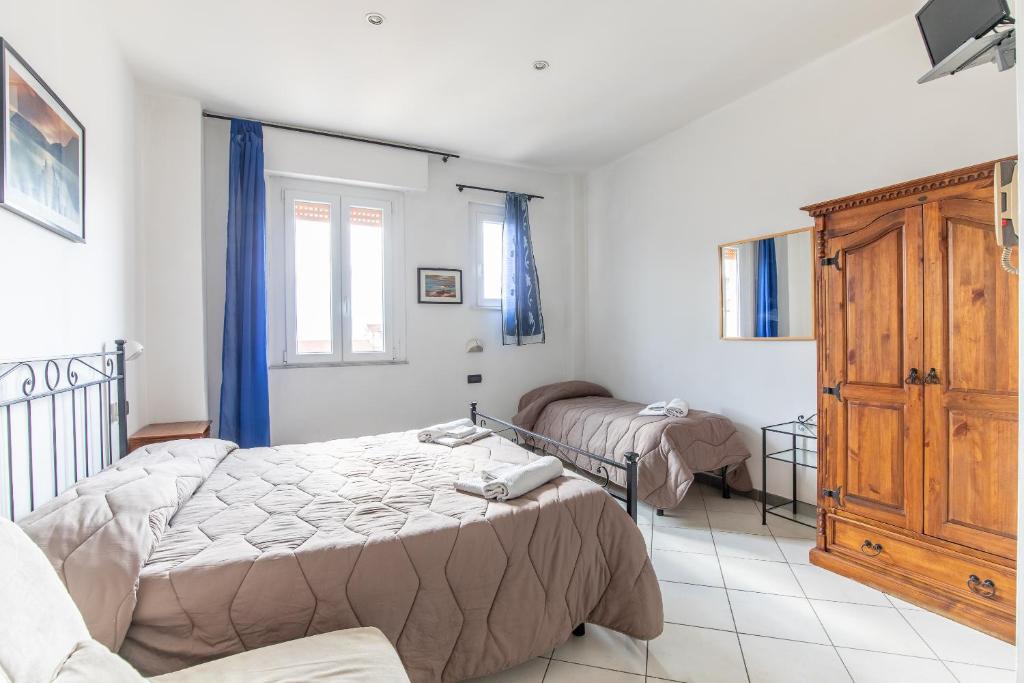 a bedroom with two beds and a cabinet at Hotel Paolina in Viareggio