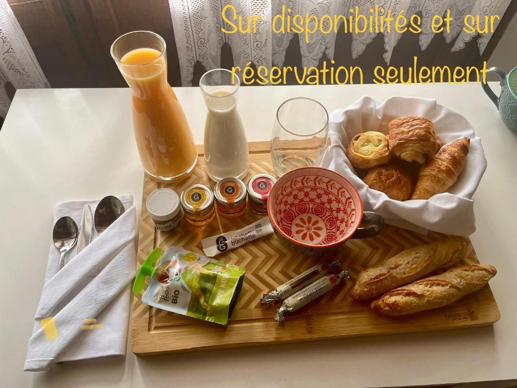 a tray of food with bread and drinks on a table at Le gîte du Brouage in Chauny