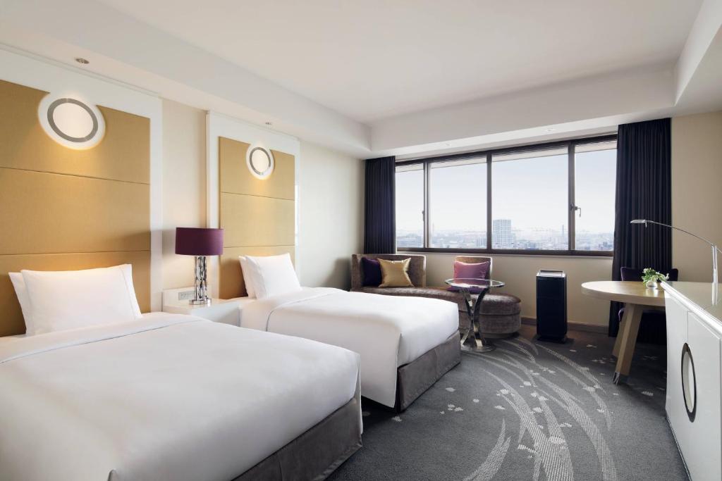 a hotel room with two beds and a chair at Tokyo Marriott Hotel in Tokyo