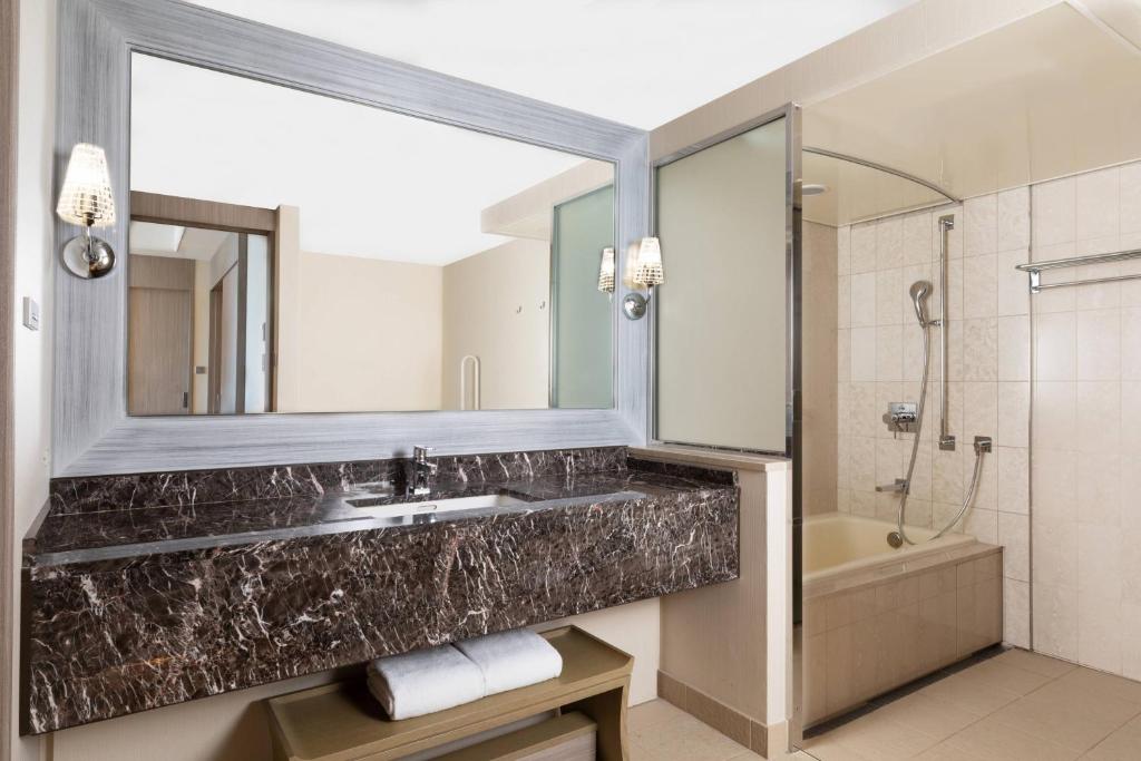 a bathroom with a sink and a mirror and a tub at Tokyo Marriott Hotel in Tokyo
