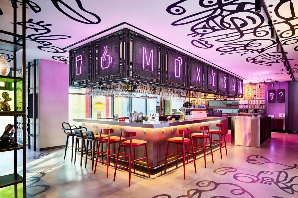 ソウルにあるMoxy Seoul Myeongdongのナイトクラブの赤いバースツール付きのバー