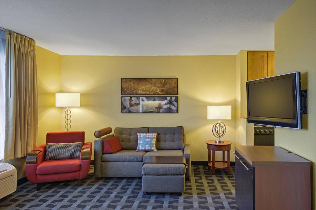 ein Wohnzimmer mit einem Sofa und einem TV in der Unterkunft TownePlace Suites by Marriott Kansas City Overland Park in Overland Park
