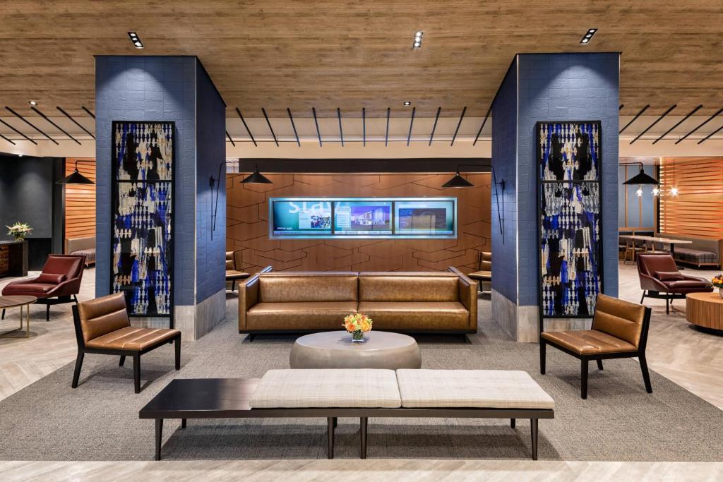 a lobby with a couch and a table and chairs at SpringHill Suites by Marriott New York Manhattan/Times Square South in New York