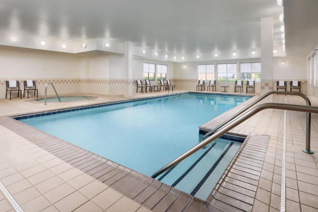 una grande piscina con sedie e tavoli di Residence Inn Potomac Mills Woodbridge a Woodbridge