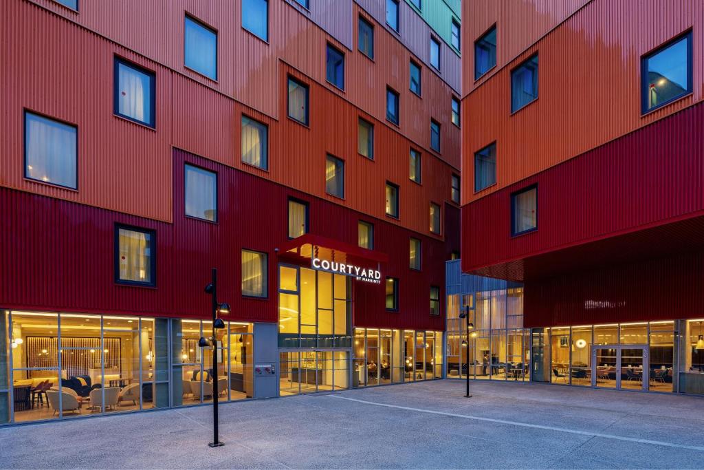a building with red and orange walls at Courtyard by Marriott Paris Charles de Gaulle Central Airport in Roissy-en-France
