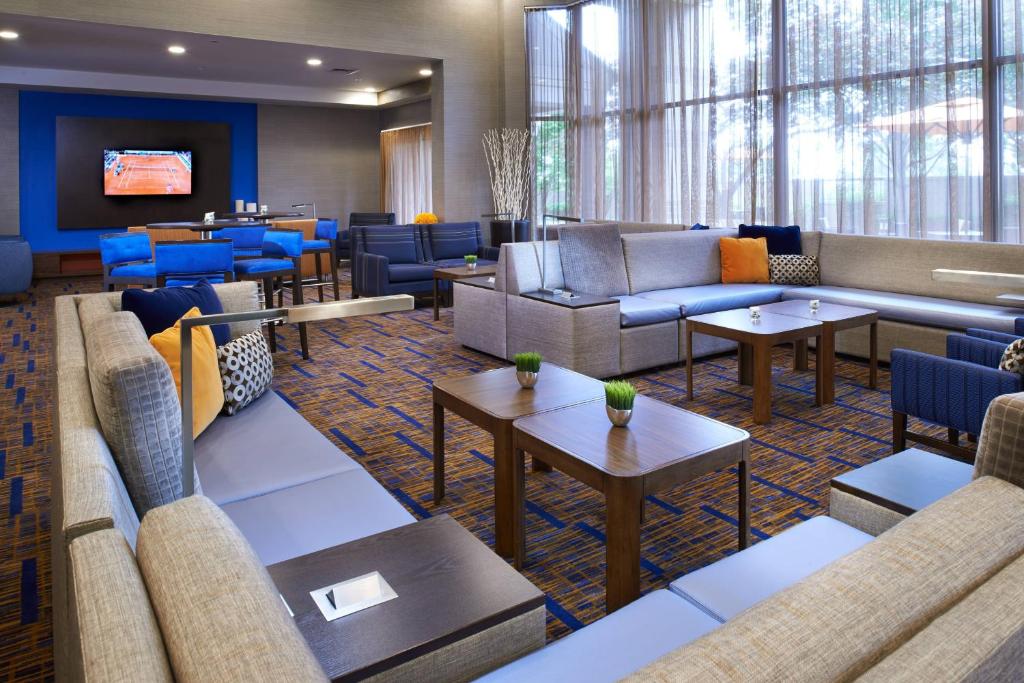a hotel lobby with couches and tables and chairs at Courtyard Kansas City Overland Park / Convention Center in Overland Park