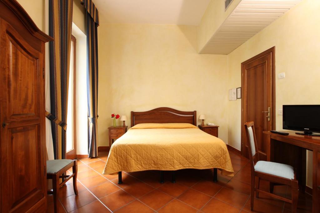una camera con un letto e una televisione di Hotel Bologna a Firenze