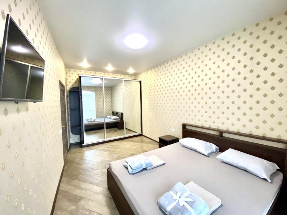 1 dormitorio con 1 cama grande y espejo en 26 Perlyna Arcadia apartment, en Odessa