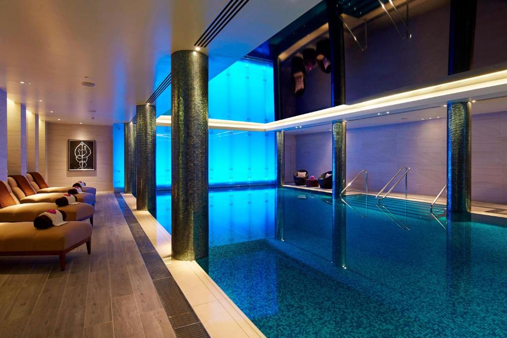 a swimming pool in a hotel with blue lighting at London Marriott Hotel Park Lane in London