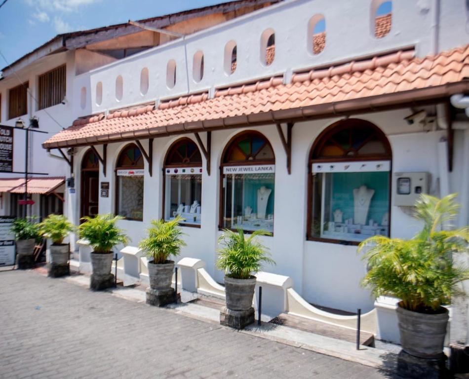 un edificio con macetas delante de él en New Old Dutch House - Galle Fort, en Galle