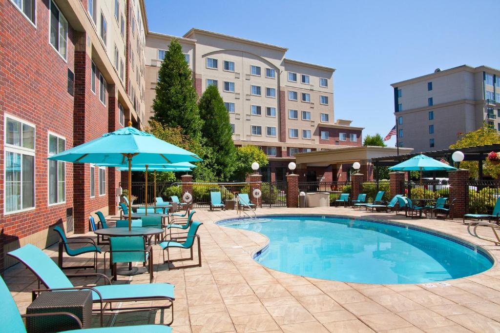 a swimming pool with chairs and tables and umbrellas at Residence Inn Seattle East/Redmond in Redmond