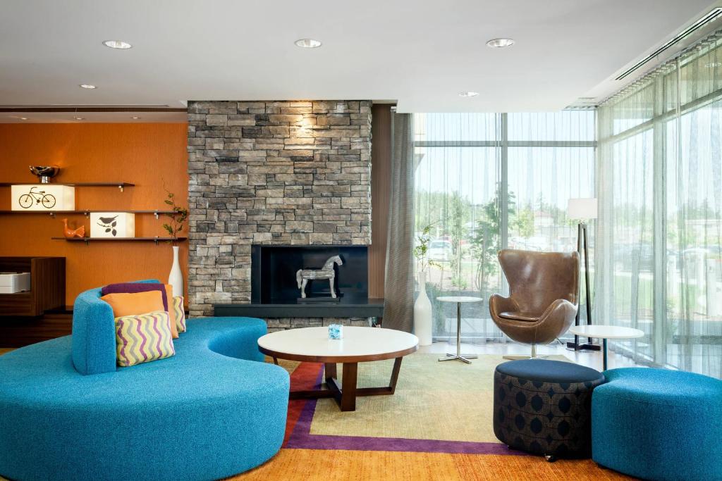 a living room with a blue couch and a fireplace at Fairfield Inn & Suites by Marriott Tacoma DuPont in DuPont