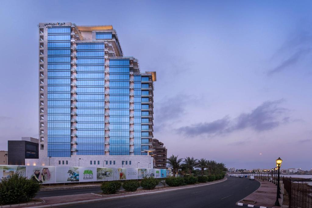 un grand bâtiment sur le côté d'une route dans l'établissement Four Points by Sheraton Jeddah Corniche, à Djeddah