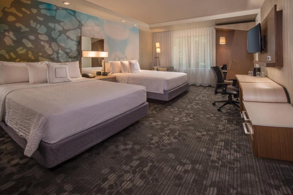 ハーシーにあるCourtyard by Marriott Hershey Chocolate Avenueのベッド2台とデスクが備わるホテルルームです。