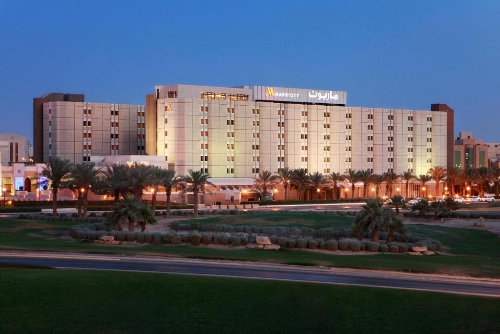 a large building with palm trees in front of it at Riyadh Marriott Hotel in Riyadh