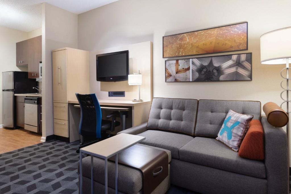 una sala de estar con sofá y escritorio en una habitación de hotel en TownePlace Suites by Marriott Bossier City, en Bossier City
