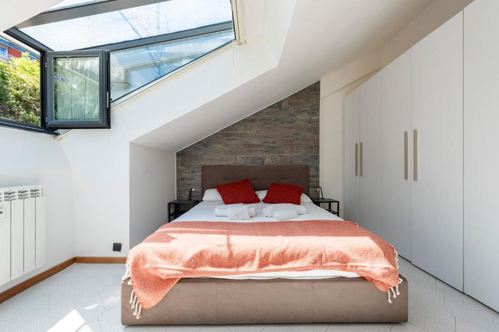 una camera da letto con un grande letto con cuscini rossi di Mansarda Romantica a Rapallo