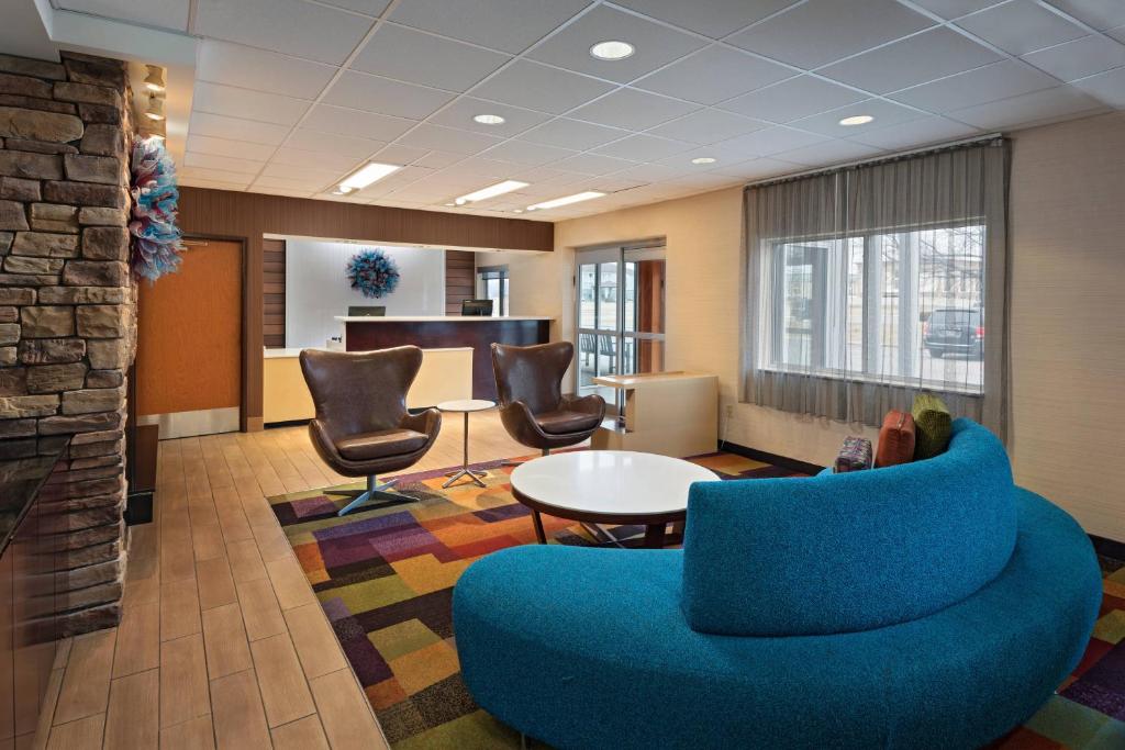 un bureau avec un canapé bleu, des chaises et une table dans l'établissement Fairfield Inn Saint Louis Collinsville, à Collinsville