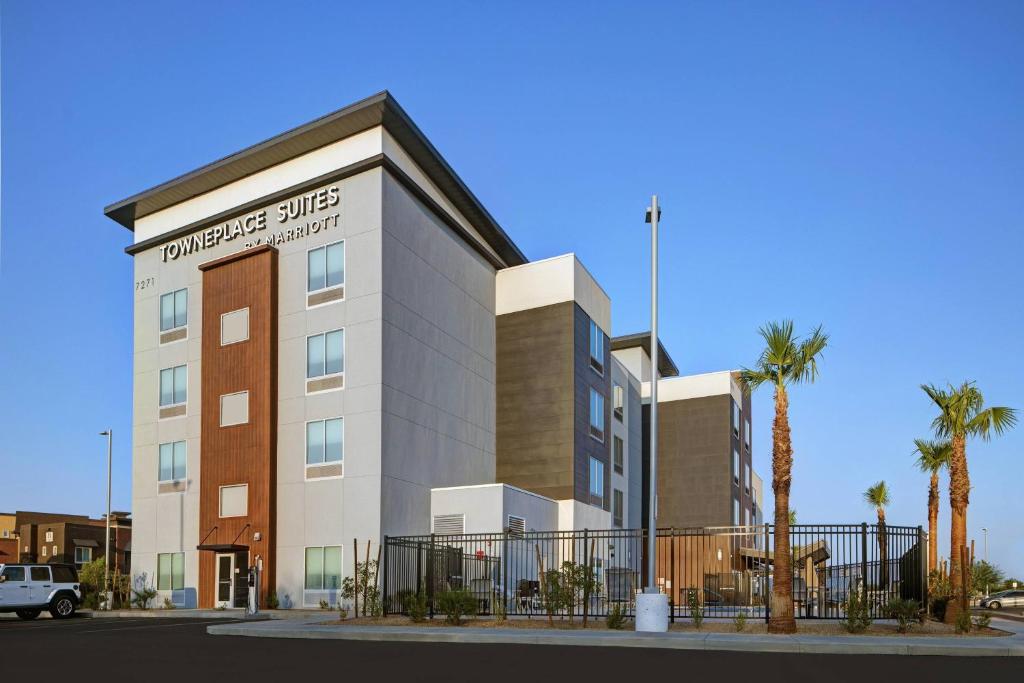 un bâtiment avec des palmiers en face de celui-ci dans l'établissement TownePlace Suites by Marriott Phoenix Glendale Sports & Entertainment District, à Glendale