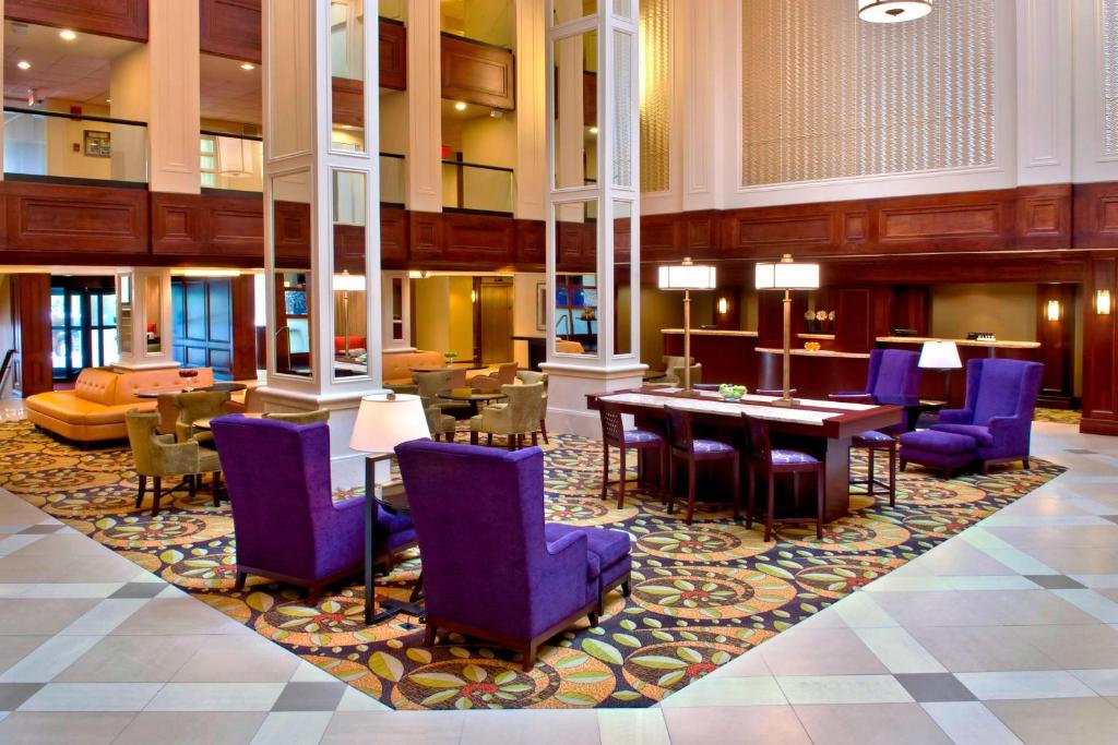 um átrio com cadeiras roxas e mesas num tapete em Stamford Marriott Hotel & Spa em Stamford