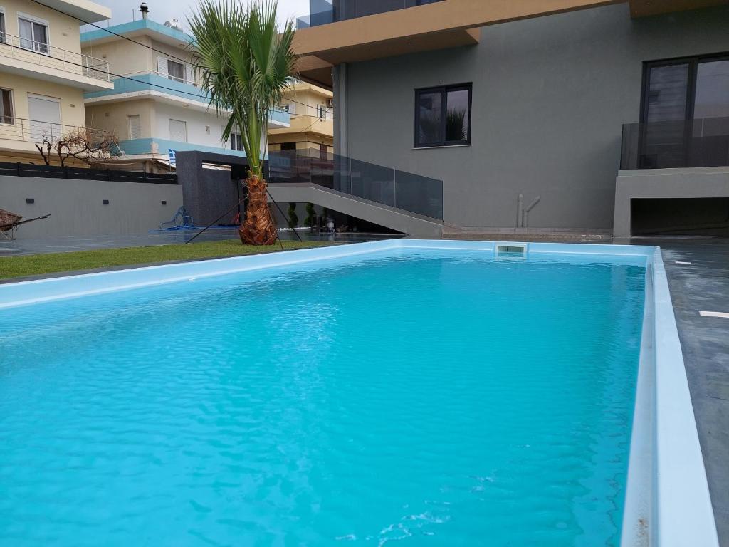 a large blue swimming pool in front of a house at Luana Monte Apartments in Amoudara Herakliou