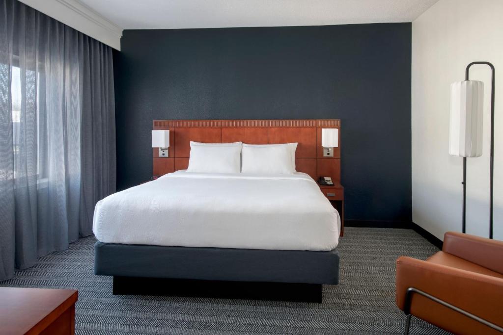 銀泉的住宿－銀泉北/白橡木萬怡酒店，卧室配有一张白色大床和一把椅子