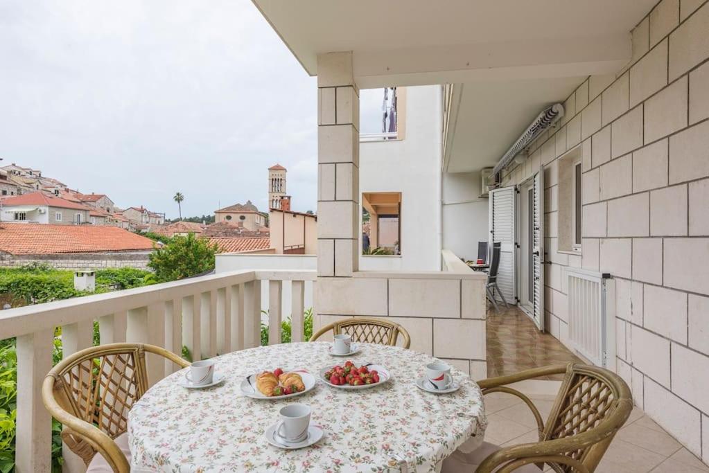 a table with a plate of fruit on a balcony at Apartment in Hvar town historic center in Hvar