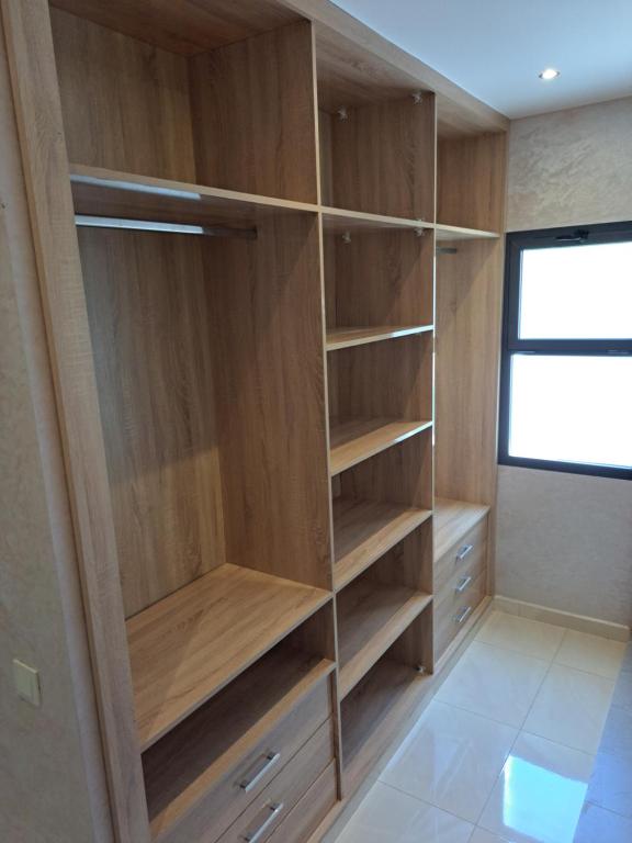 a closet with wooden shelves and a window at Blue Horizon-Ghougine in Tangier