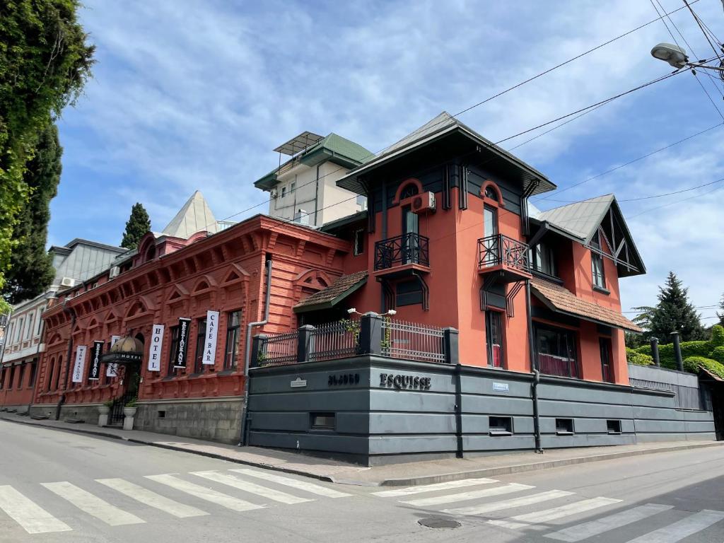 un gran edificio rojo al lado de una calle en Prestige Palace - Esquisse Hotel, en Tiflis