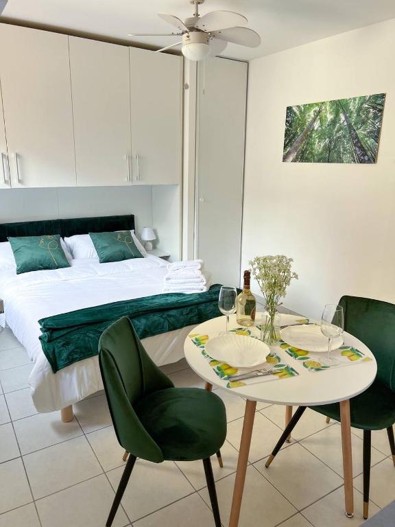 une chambre avec un lit, une table et des chaises dans l'établissement charmant studio à Menton, à Menton