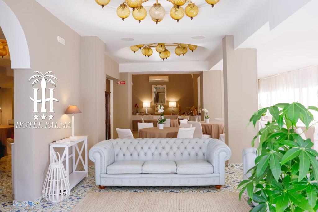 un soggiorno con divano bianco e tavolo di Hotel Palma a Castellammare di Stabia