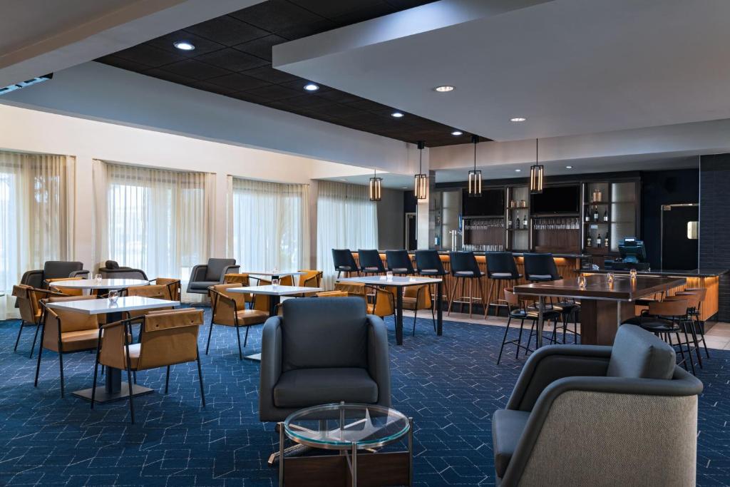 a restaurant with tables and chairs and a bar at Courtyard by Marriott San Antonio Airport in San Antonio