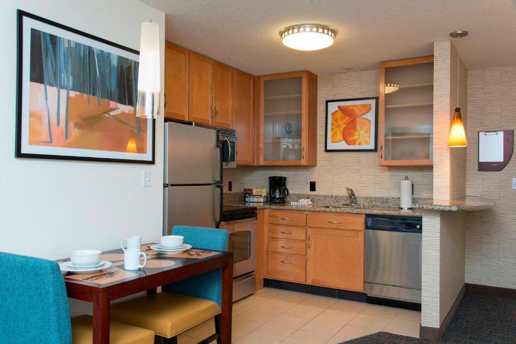 a small kitchen with a table and a refrigerator at Residence Inn Toledo Maumee in Maumee