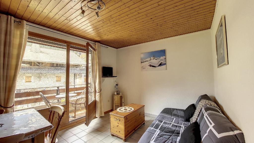 een slaapkamer met een bed, een tafel en een raam bij Schuss 6 appartement 4 pax au pied des pistes in Saint-Jean-dʼAulps